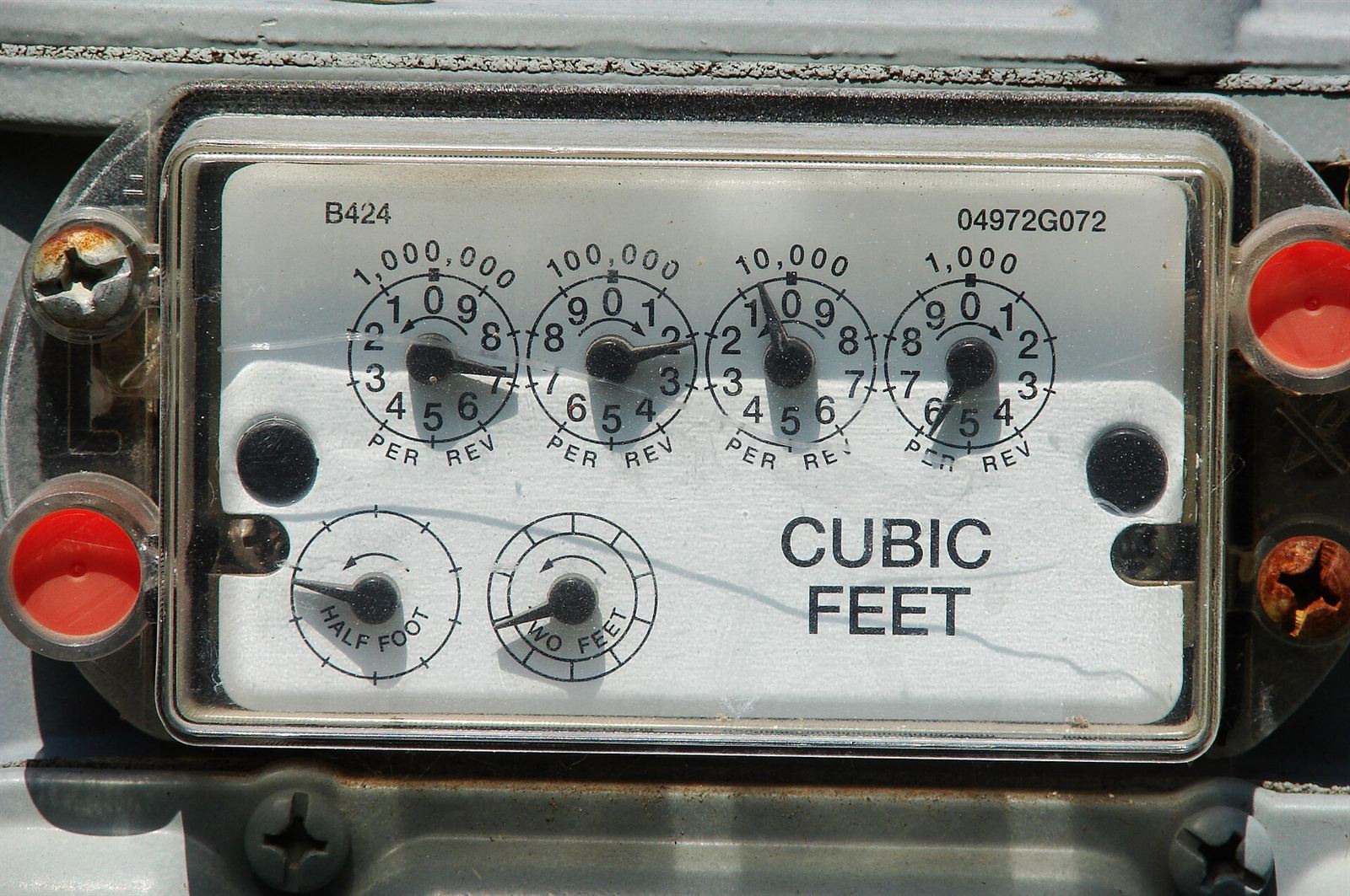 The dials of an old gas meter, reading in cubic feet