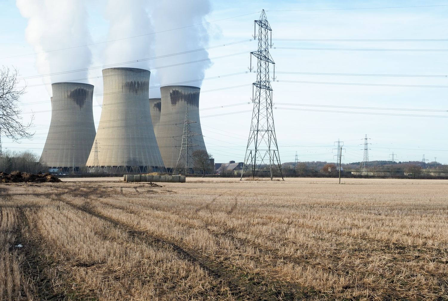 Drax power station and pylons beyond a stubble field